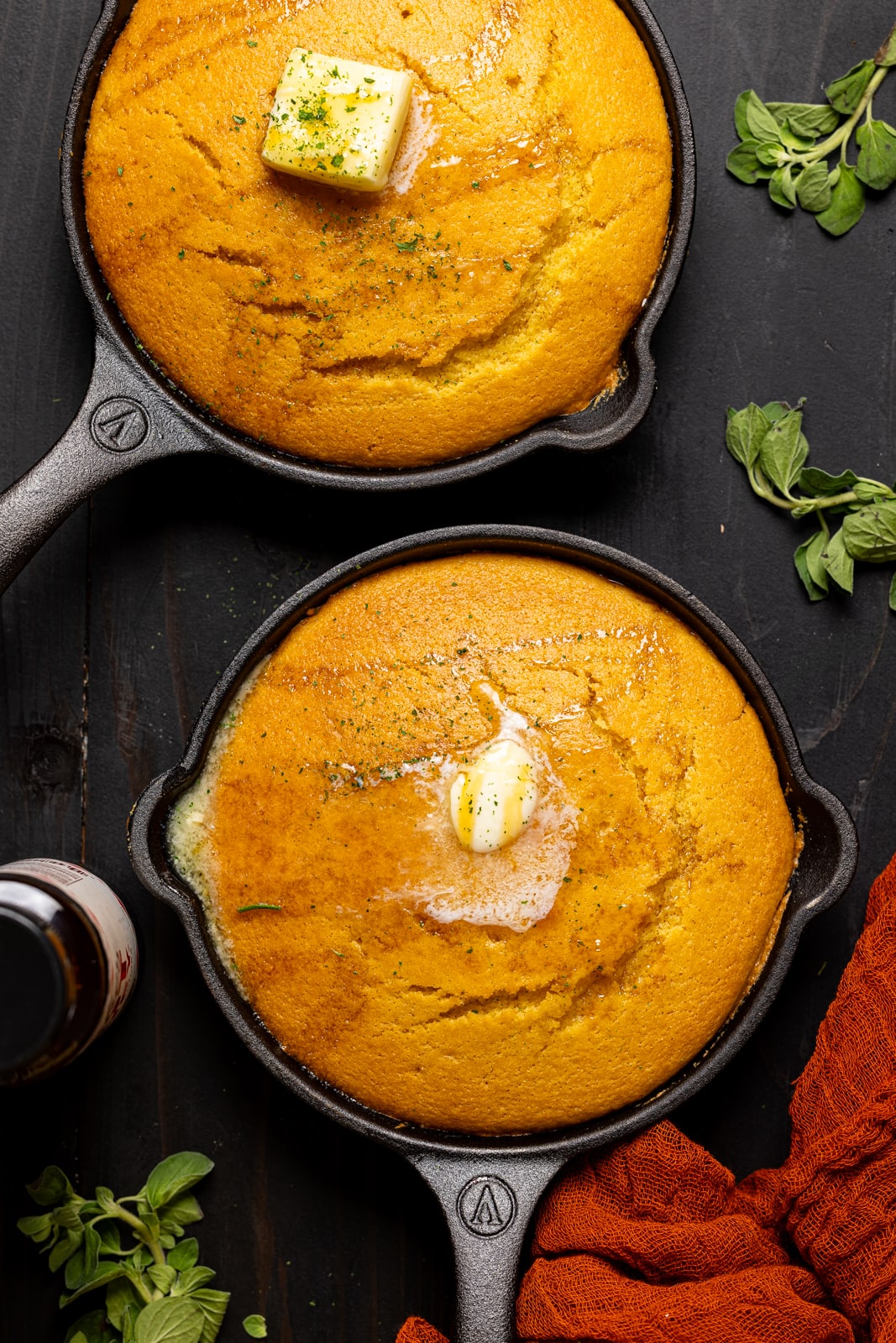 Up close shot of cornbread in a mini skillet with butter.