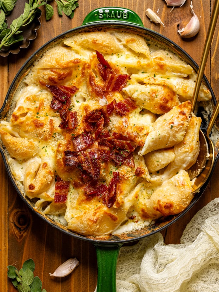 Baked mac and cheese in a green skillet topped with bacon.