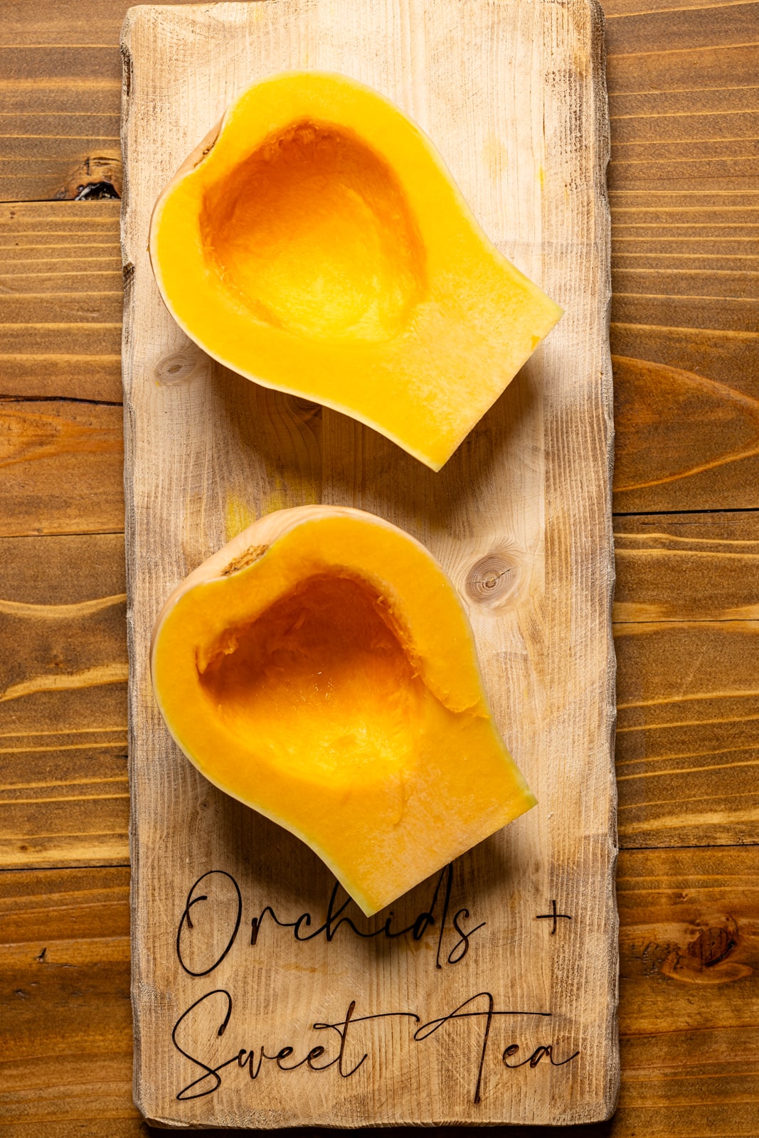 Halved butternut squash on a cutting board.