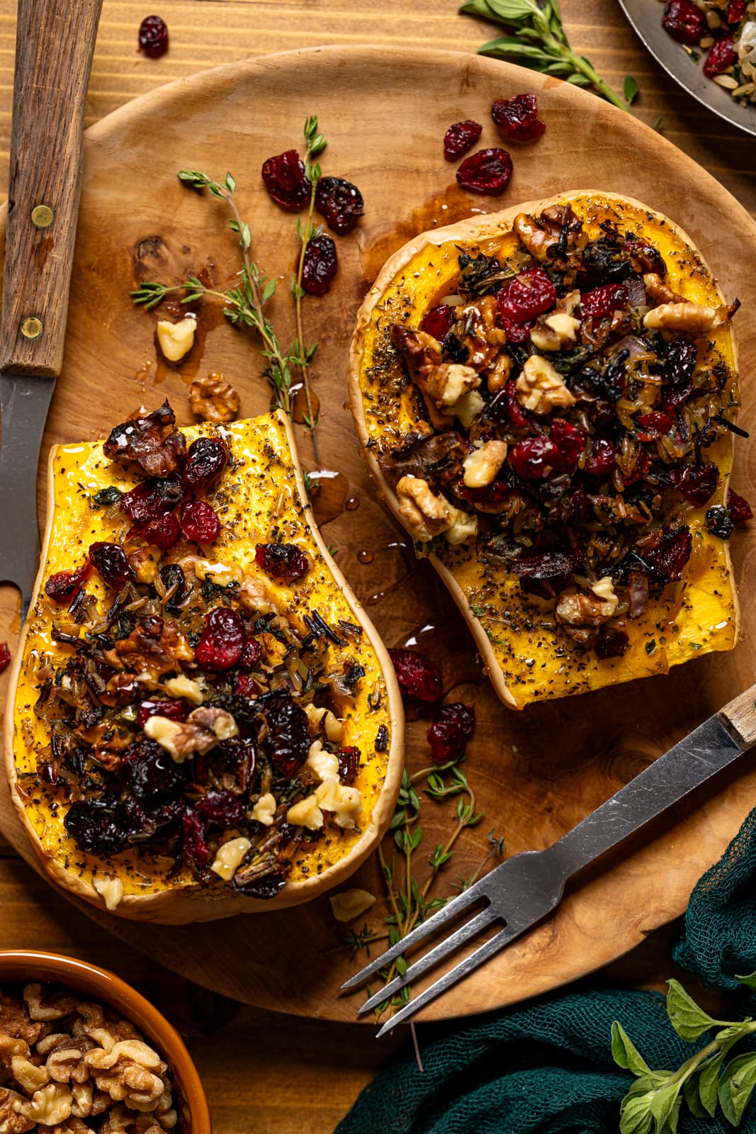 Up close shot of stuffed butternut squash with two forks and garnish.