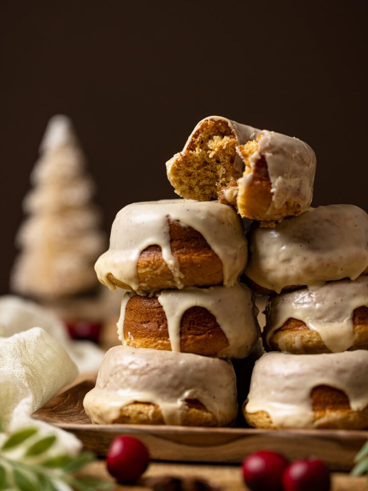 Stack of donuts with a bitten one on top.