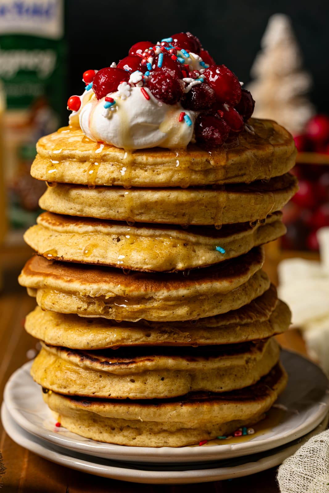 Up close shot of stack of pancakes with toppings.