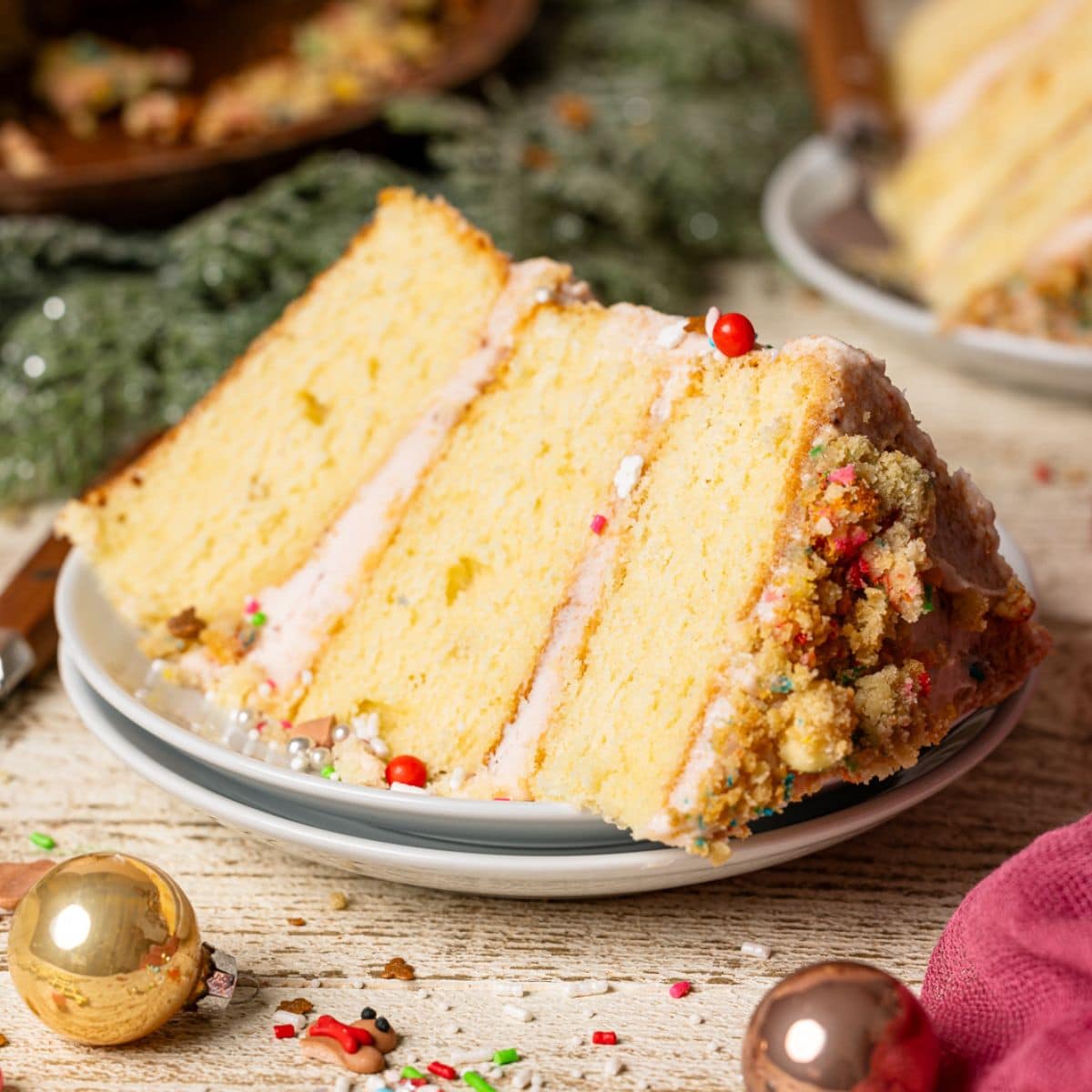 Slice of cake with holiday decor on a white wood table.