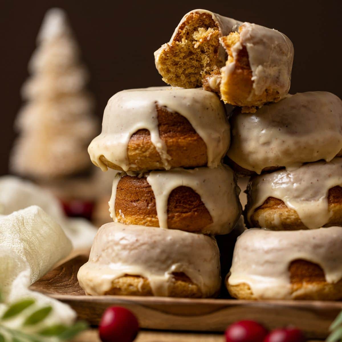 Stack of donuts with a bitten one on top.