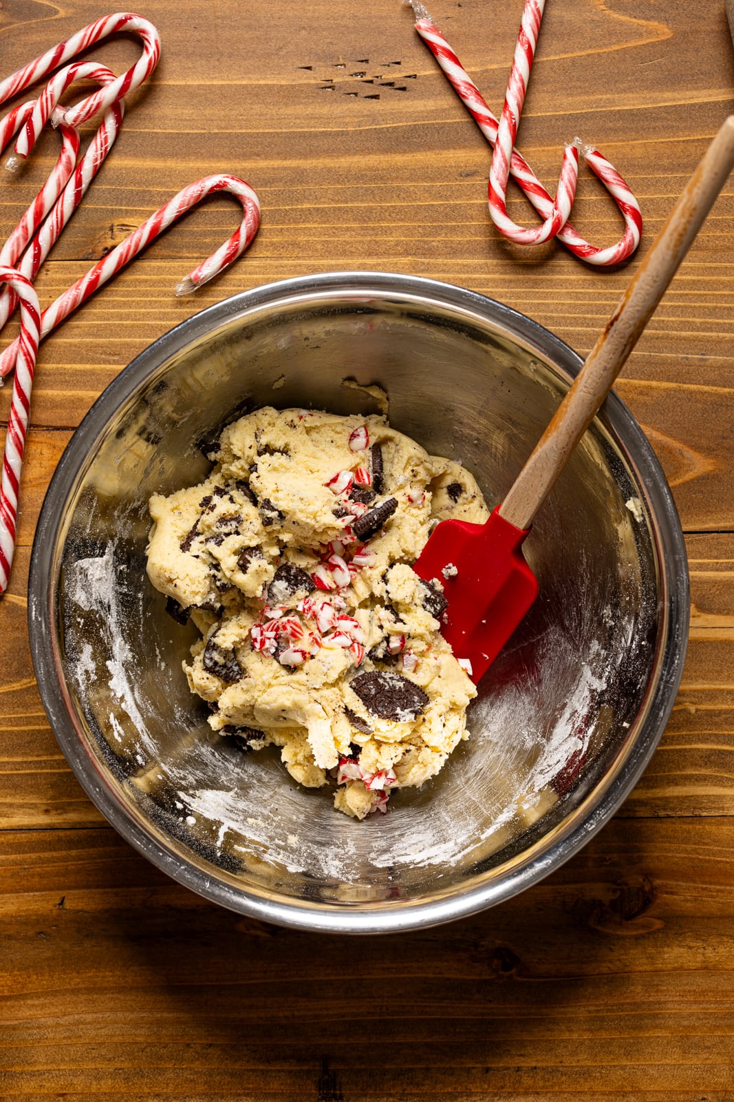 Bowl with cookie batter with red spatula and candy canes.