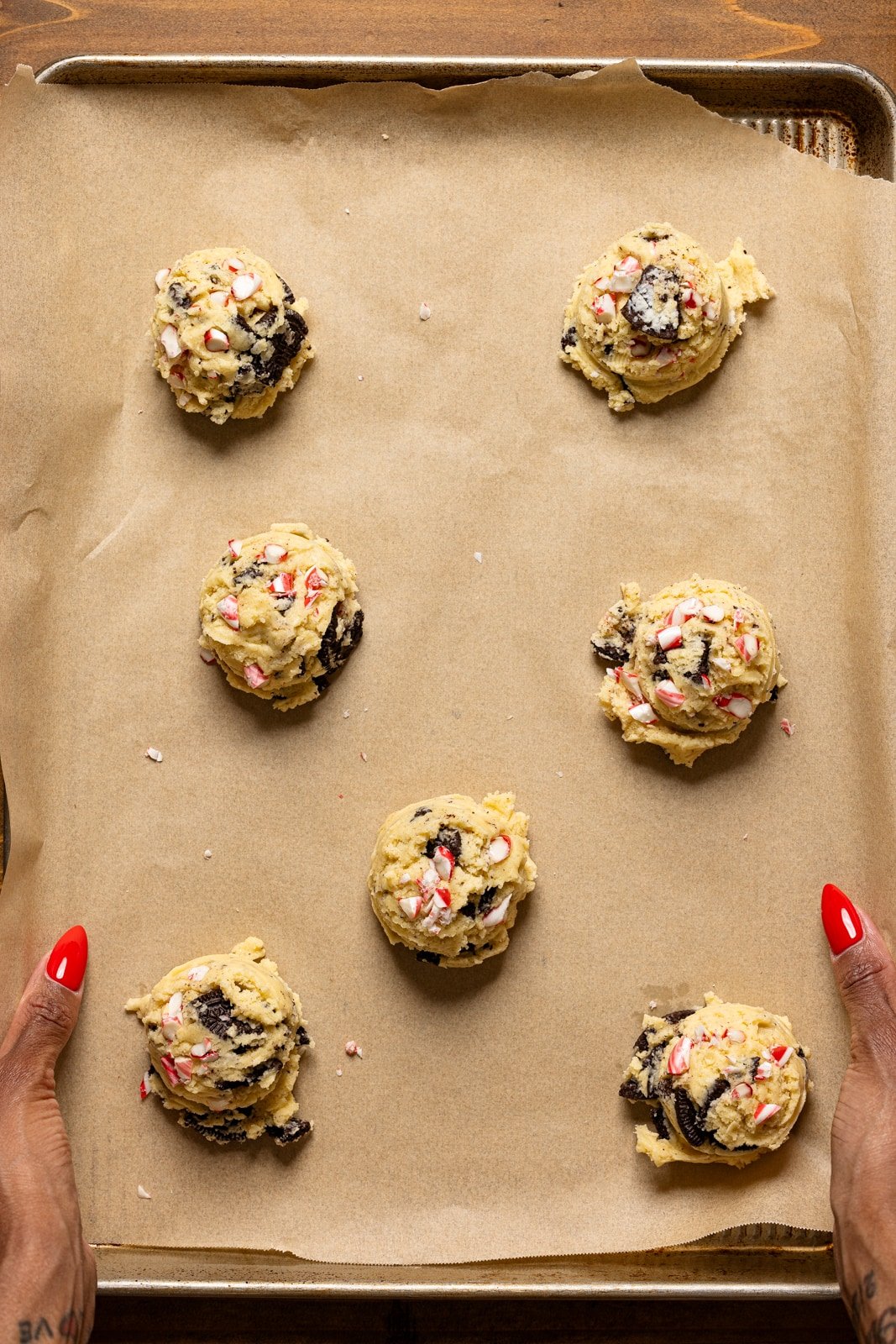 Scooped cookie dough on a baking sheet with parchment paper. 