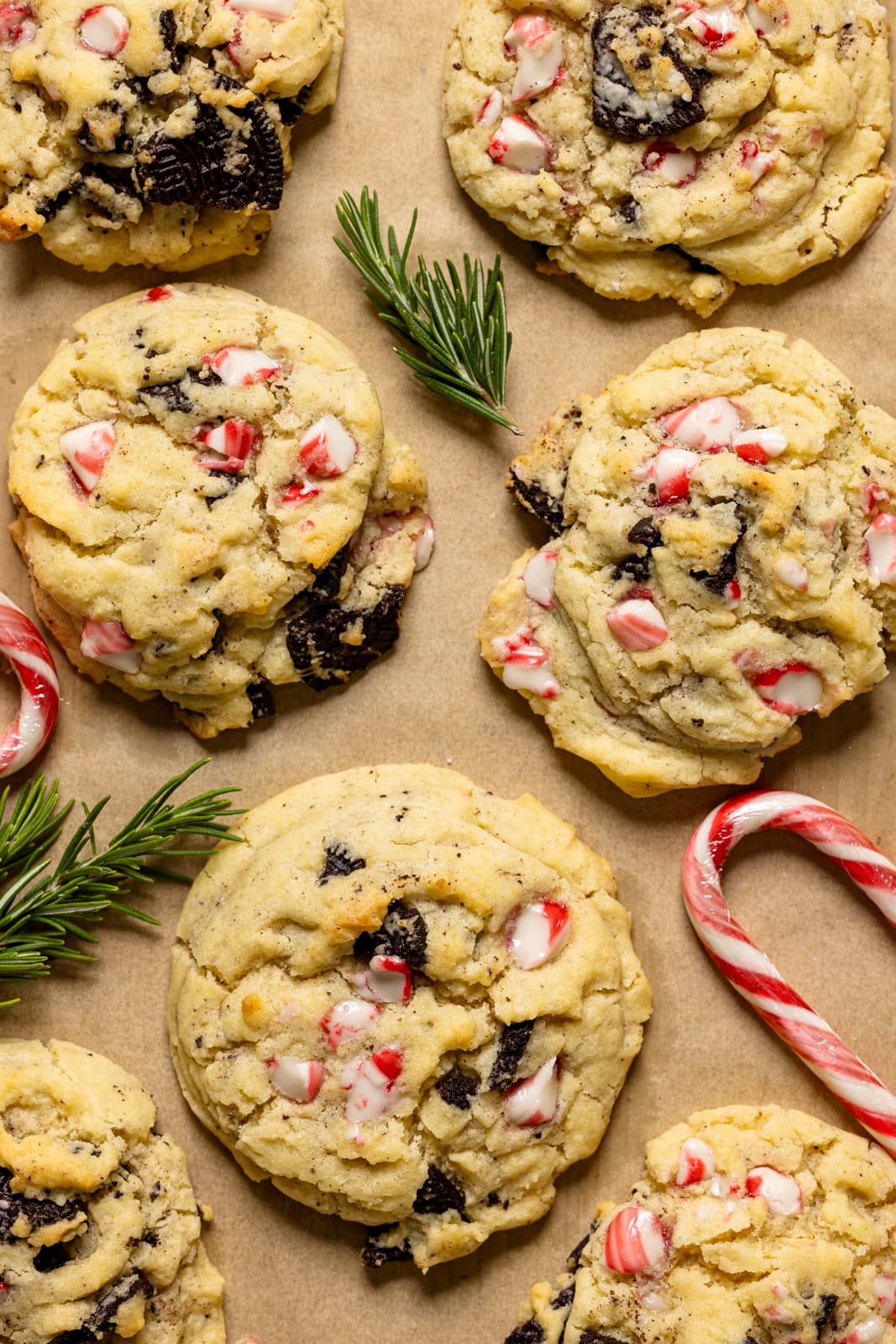 Up close shot of baked cookies on a baking sheet with parchment paper with candy canes.