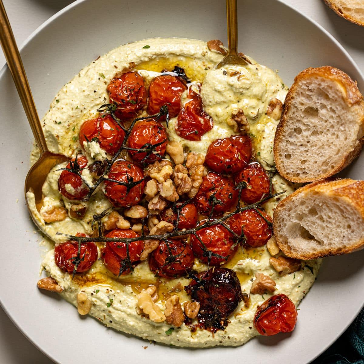 Up close shot of whipped feta dip with a spoon and fork with bread.