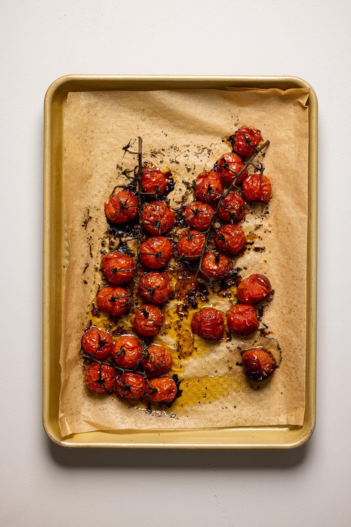 Roasted tomatoes on a baking sheet with parchment paper.