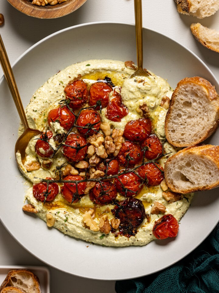 Up close shot of whipped feta dip with a spoon and fork with bread.