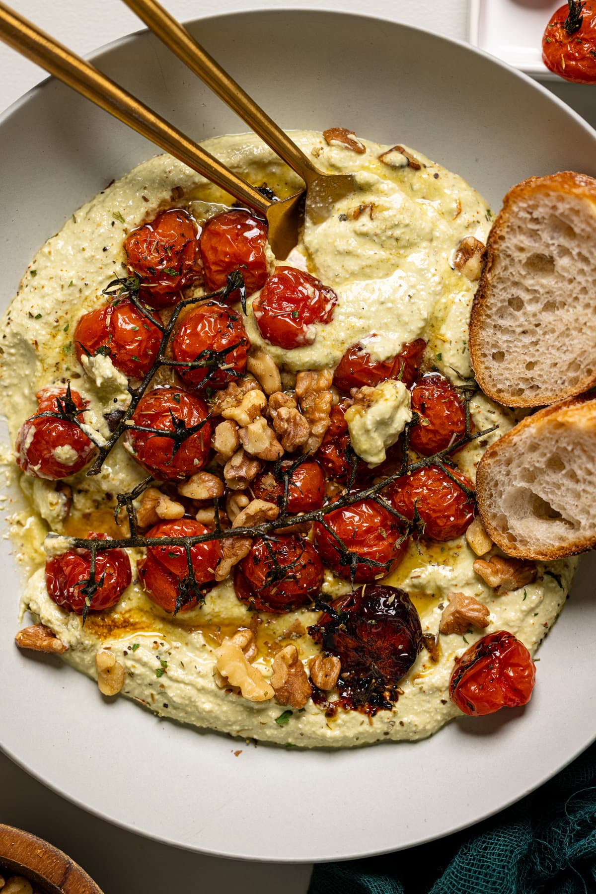 Overhead shot of whipped feta in a plate with fork and side of bread.