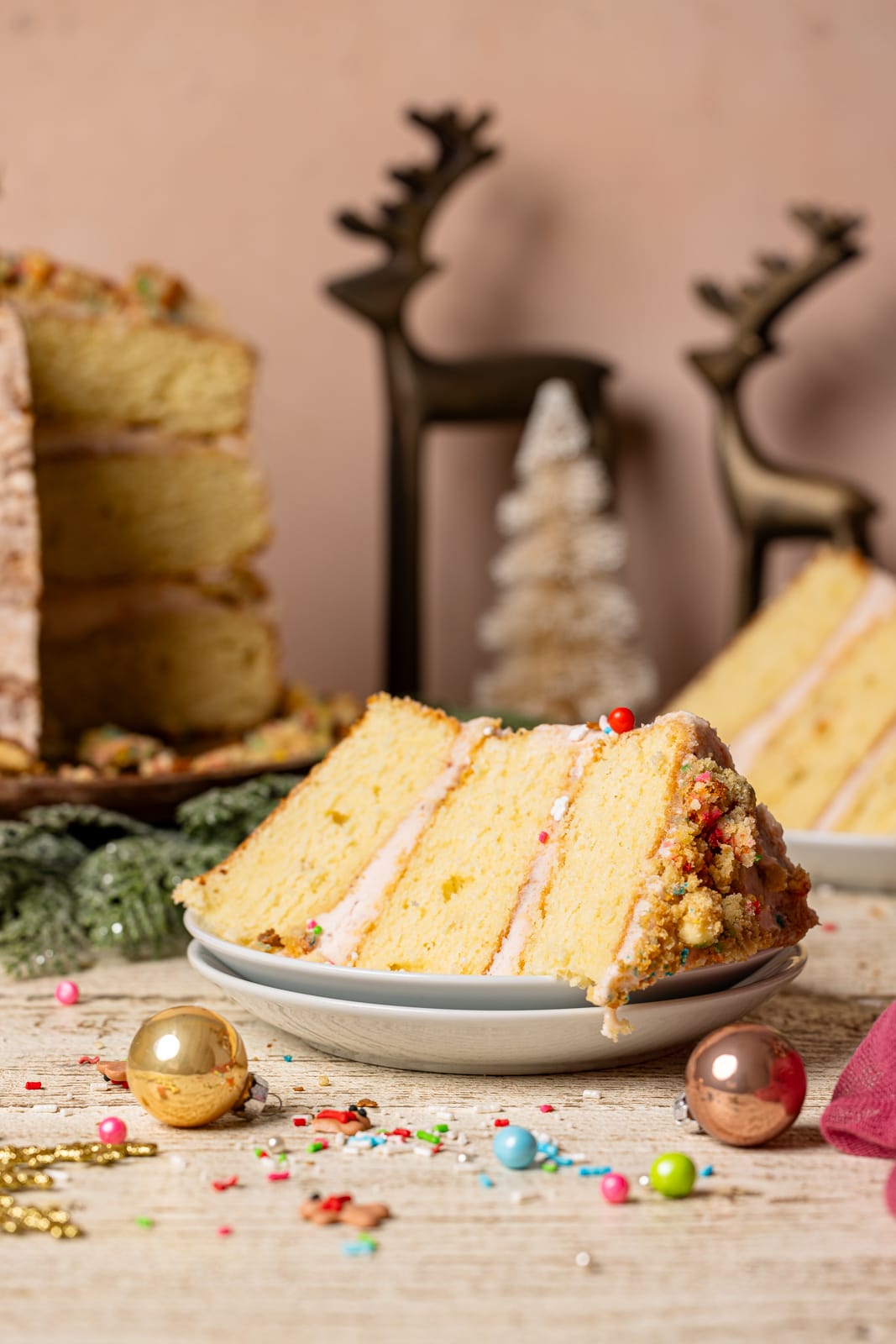 Slice of sugar cookie cake on a white plate with cake slices in the background.