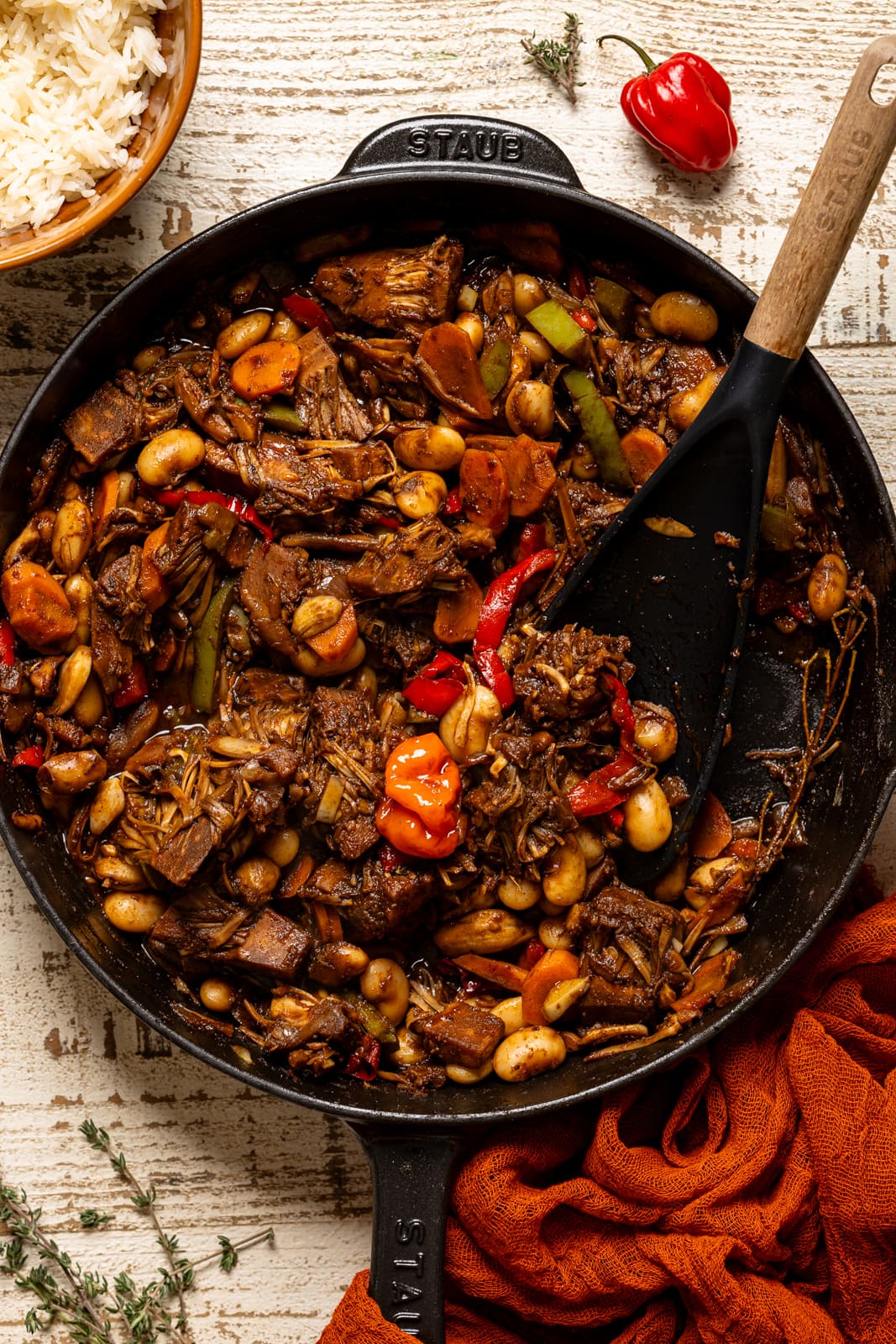 Cooked plant-based oxtail in a skillet with a black spoon. 