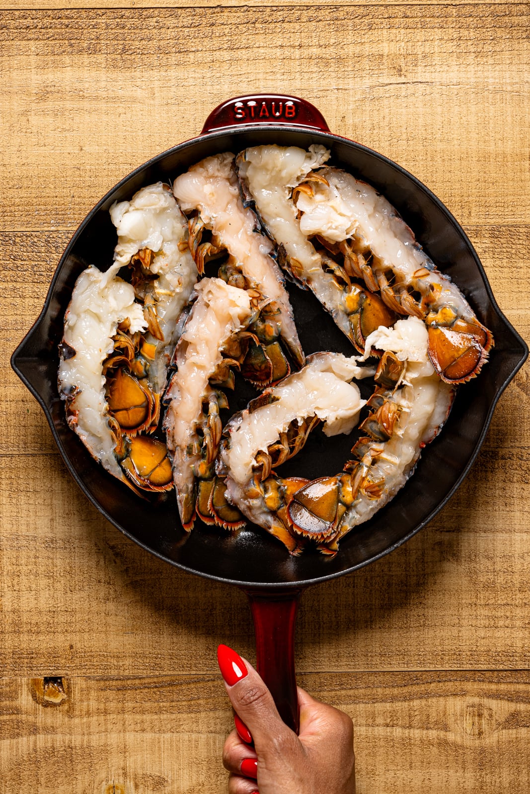 Lobster tails prepped in a skillet.