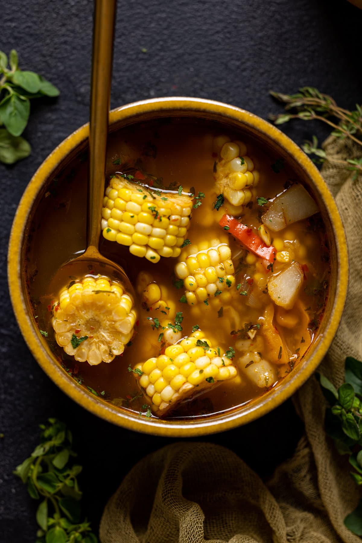 Corn soup in a yellow bowl with a spoon.