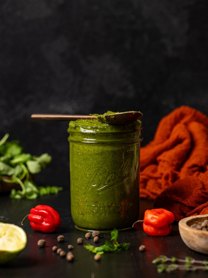 Green seasoning in a mason jar with a spoon.