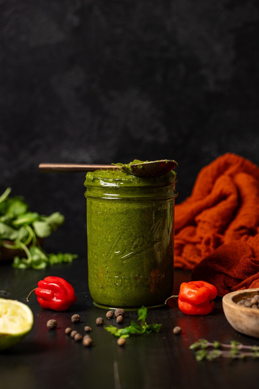 Green seasoning in a mason jar with a spoon.
