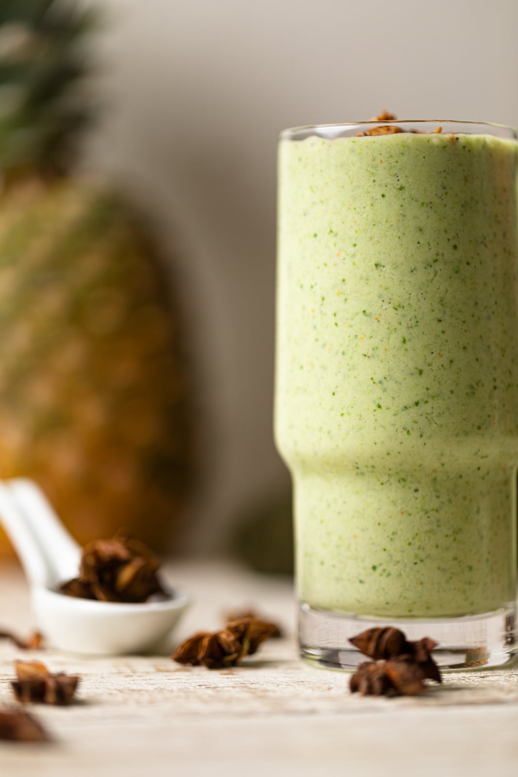 Smoothie in a glass with a pineapple on the side.