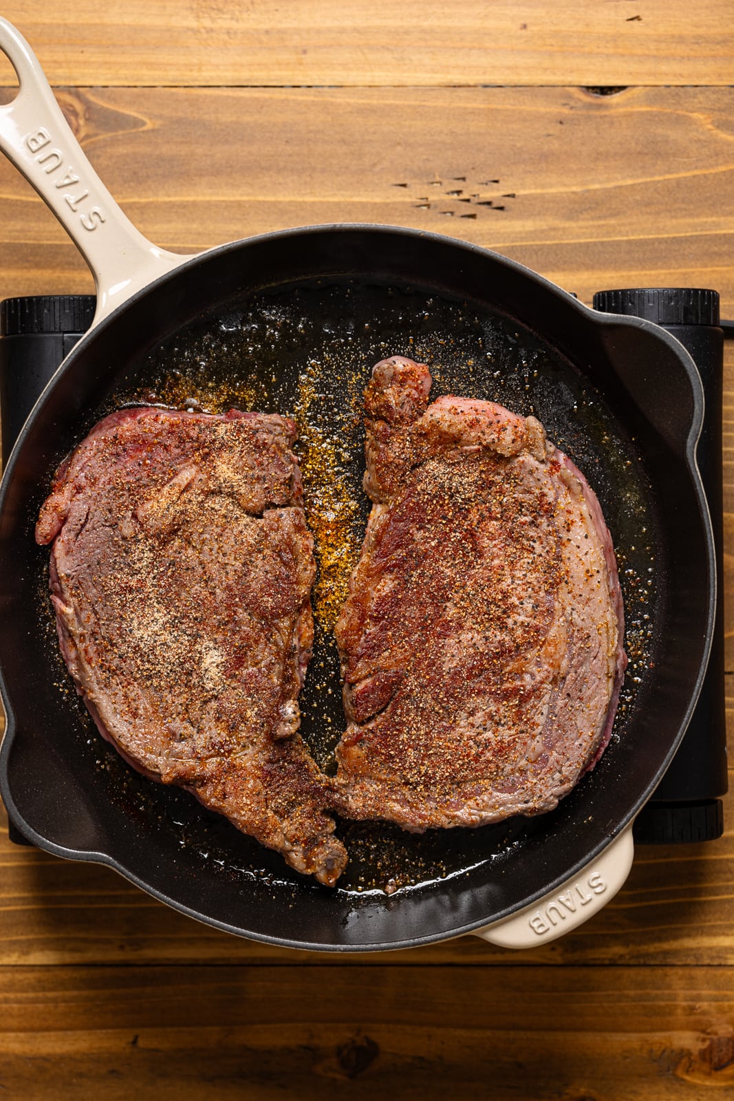 Steak being seared in a skillet on it's opposite side.