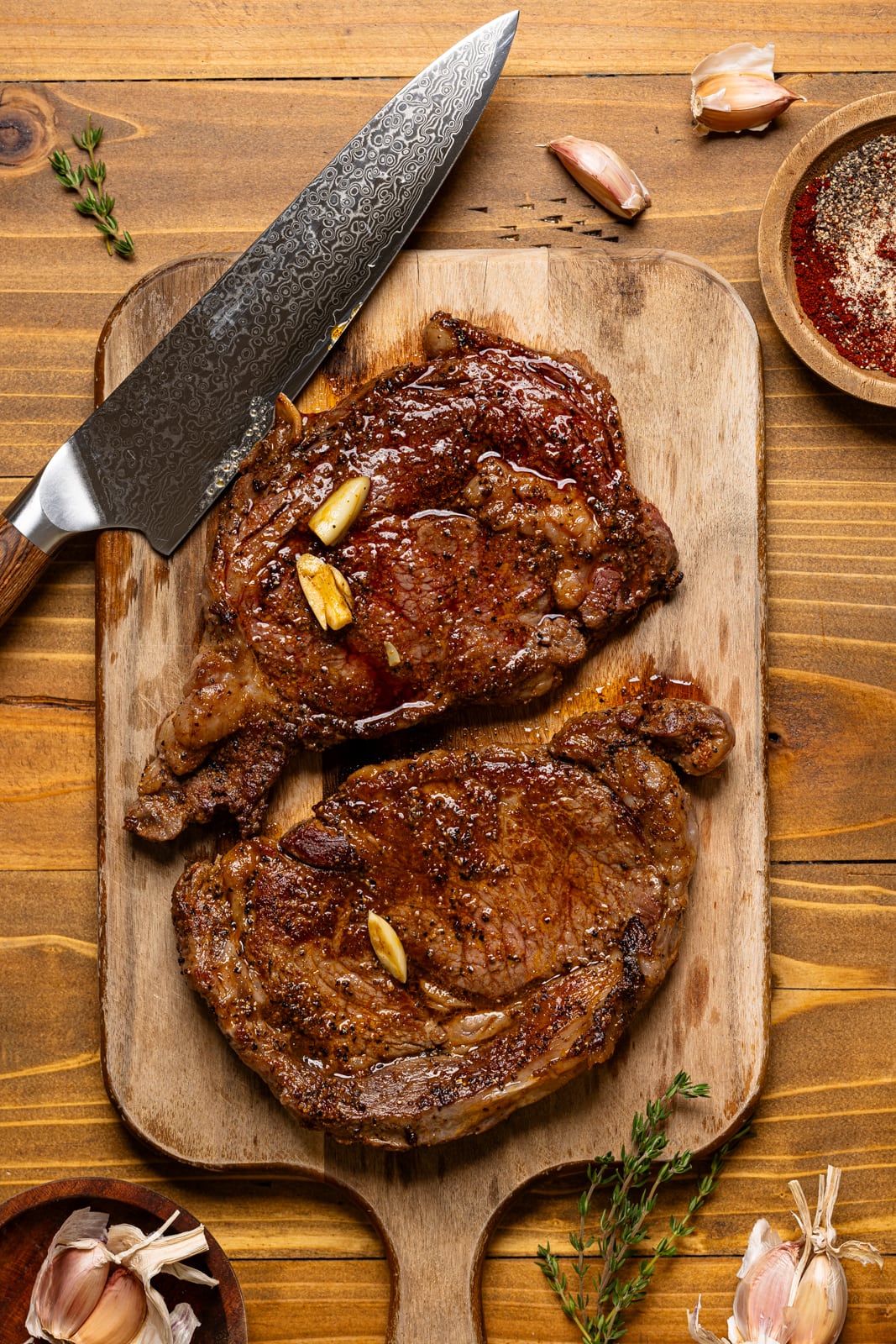 Letting the steak rest on a cutting board with a knife.