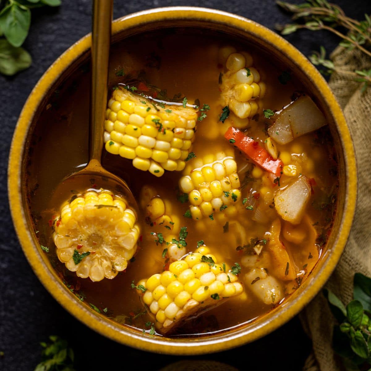 Corn soup in a wooden bowl with a spoon.