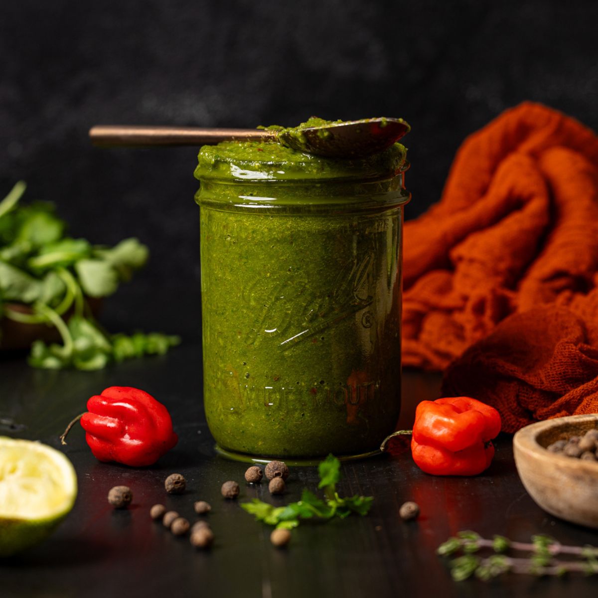 Green seasoning in a mason jar with a spoon.