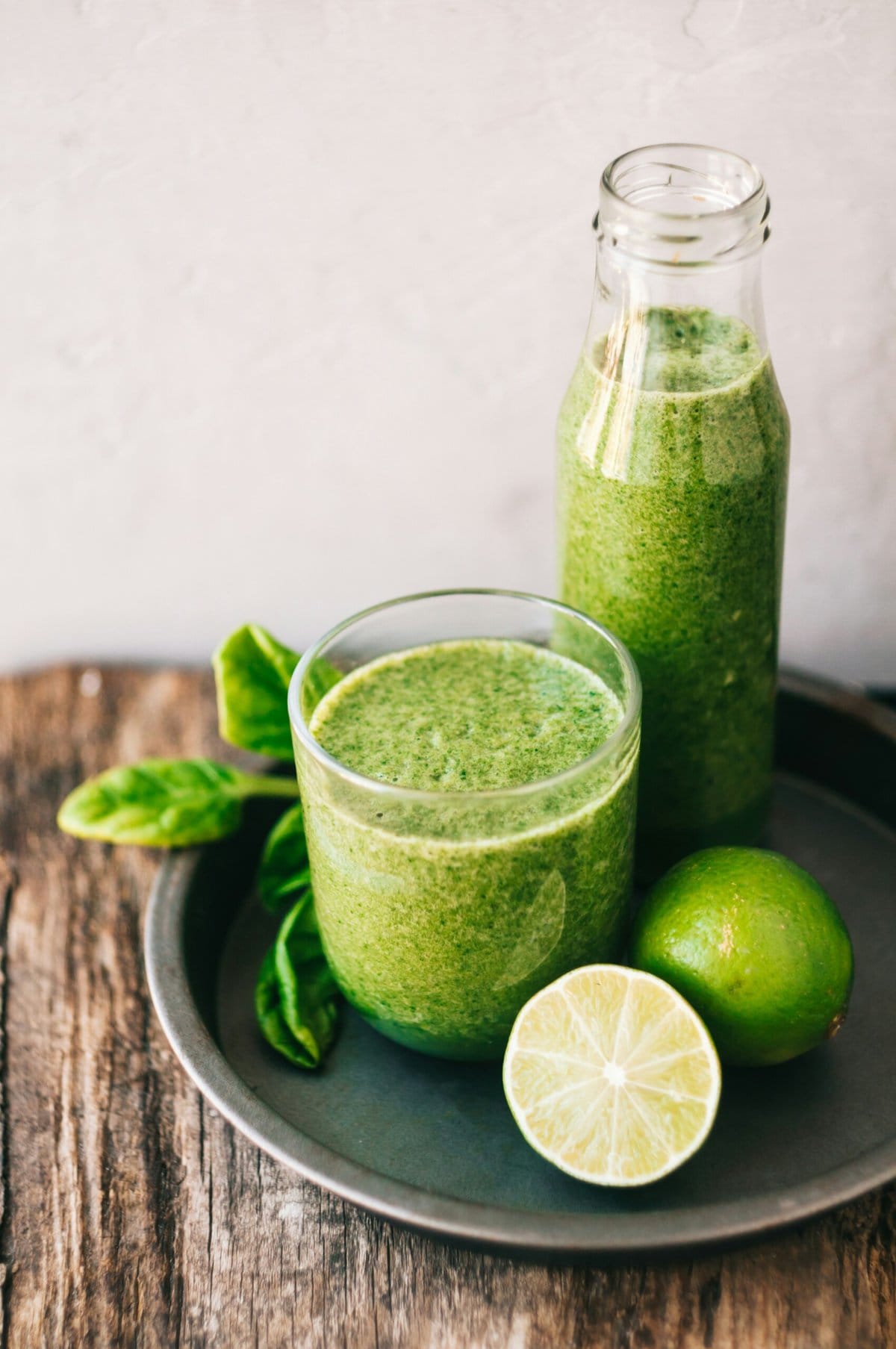 Healthy green juice in glass with lime.