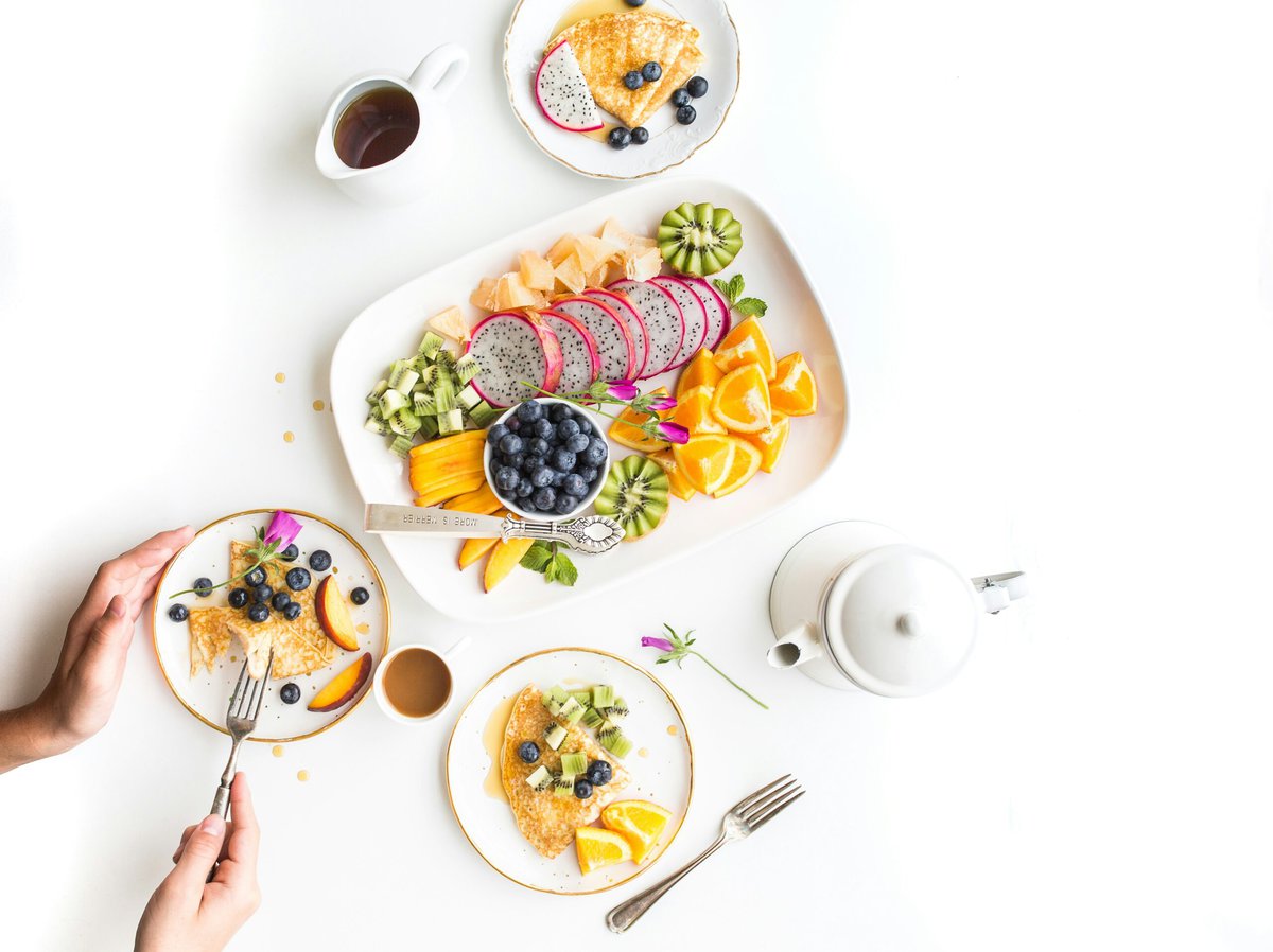 Fruits on white serving plates.