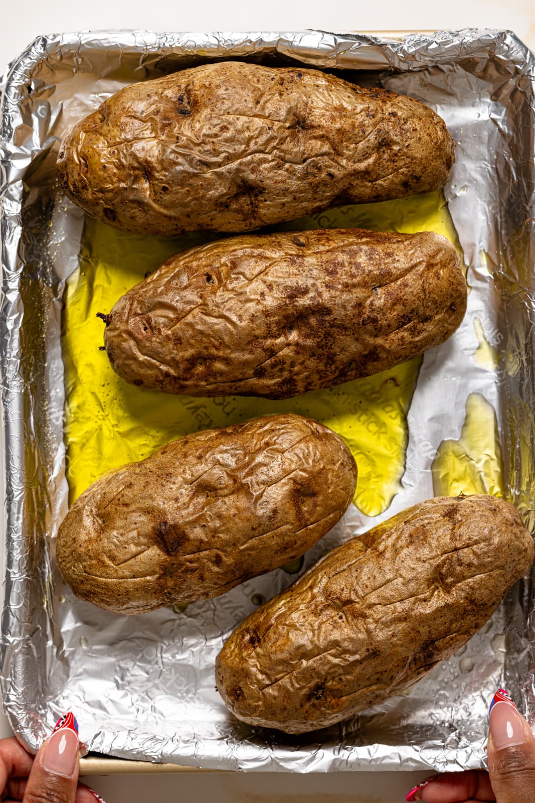 Cooked potatoes on a baking sheet with foil paper.