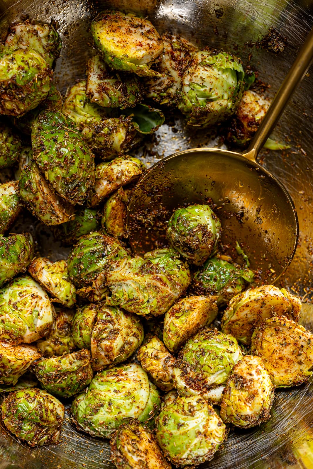 Up close shot of seasoned Brussels sprouts with a spoon.