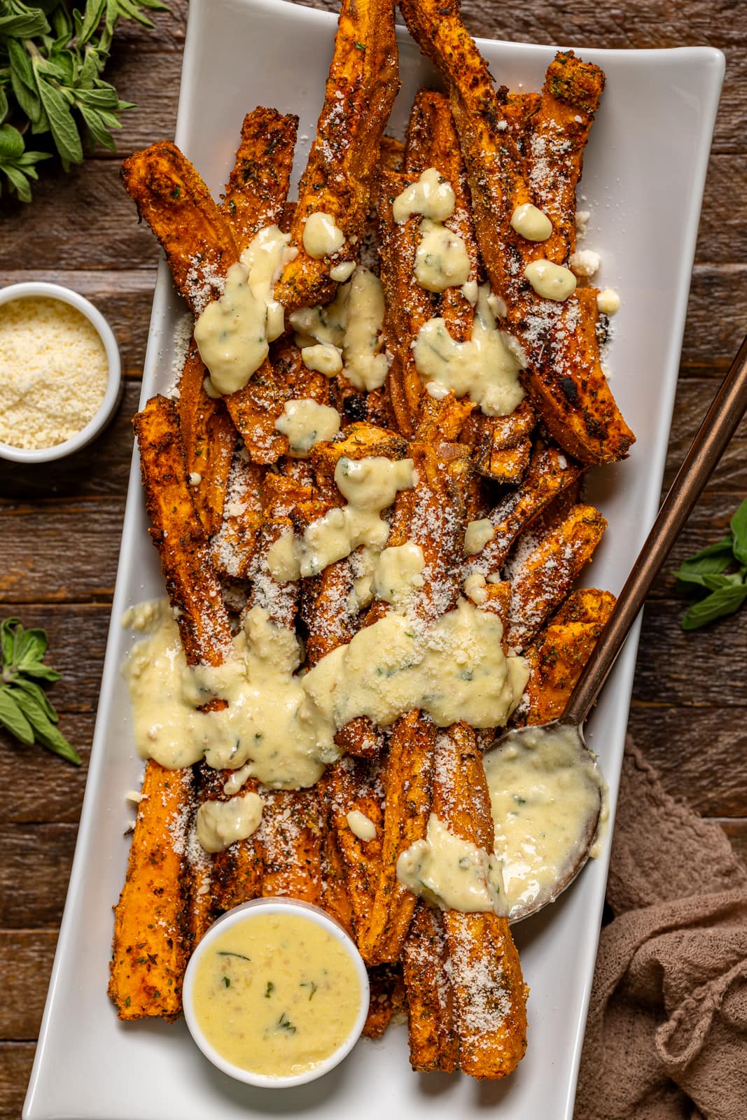 Fries on a white platter with sauce smothered on top.