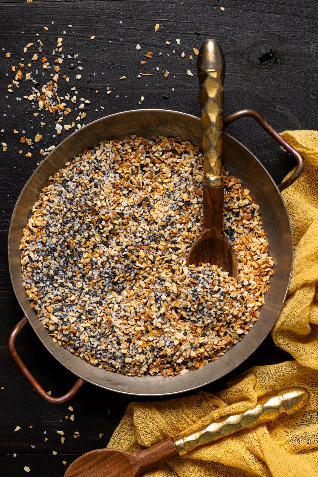 Seasoning in a dish with two spoons.