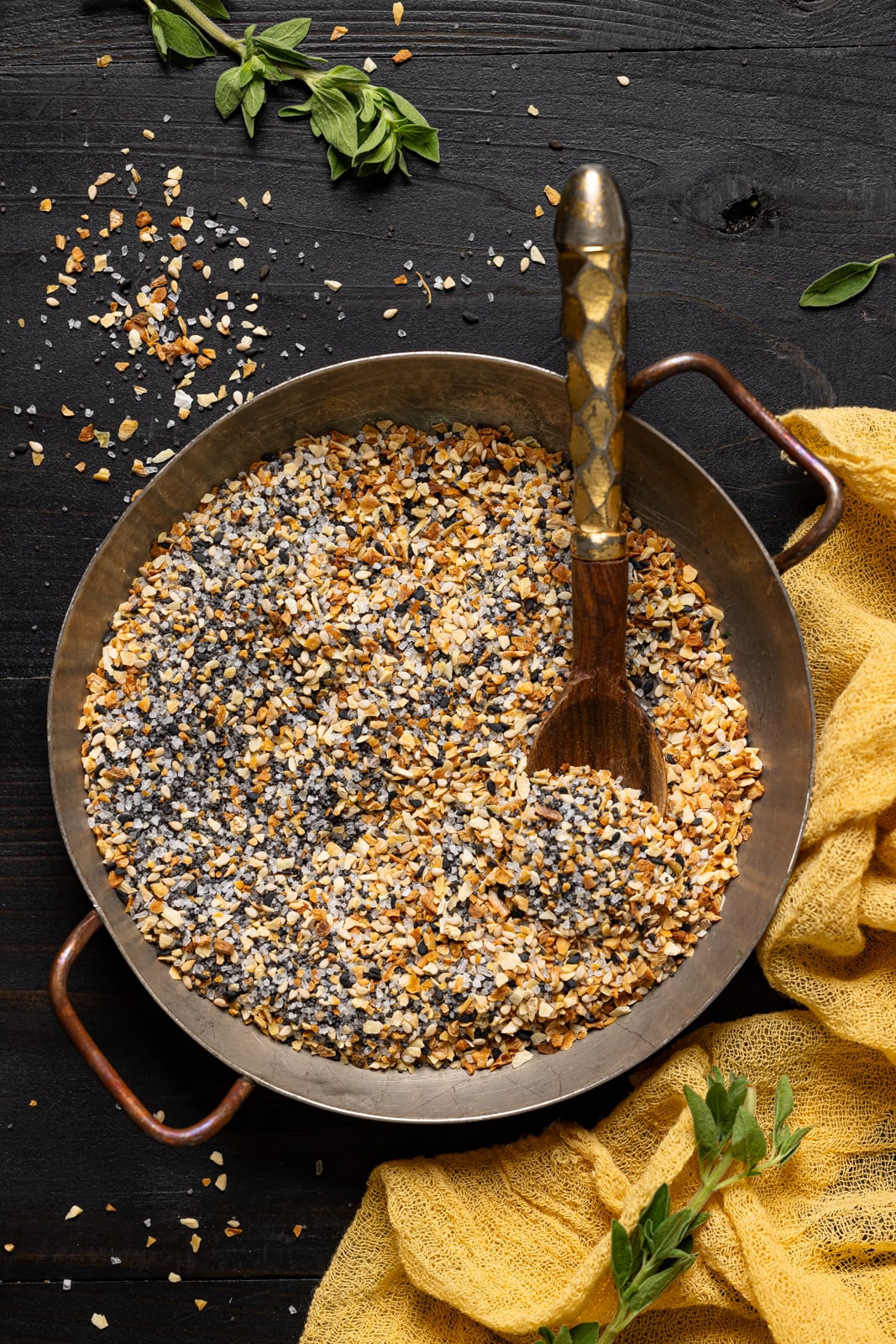 Seasoning in a dish with a spoon and yellow napkin.