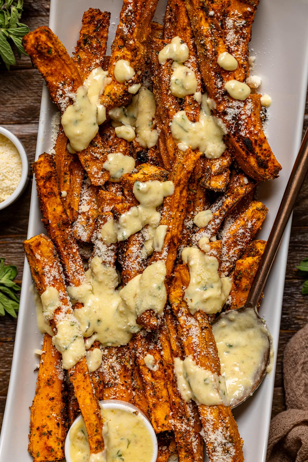 Sauce on sweet potato fries with a spoon.