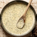 Homemade Alfredo sauce in a skillet with a wooden spoon.