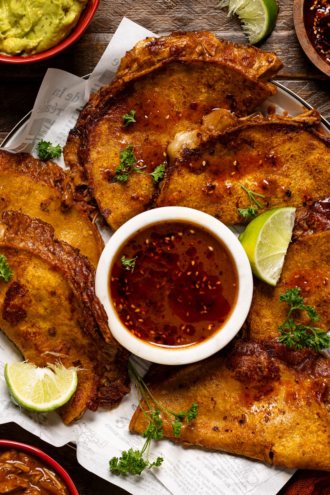 Up close shot of tacos with dipping sauce and lime.