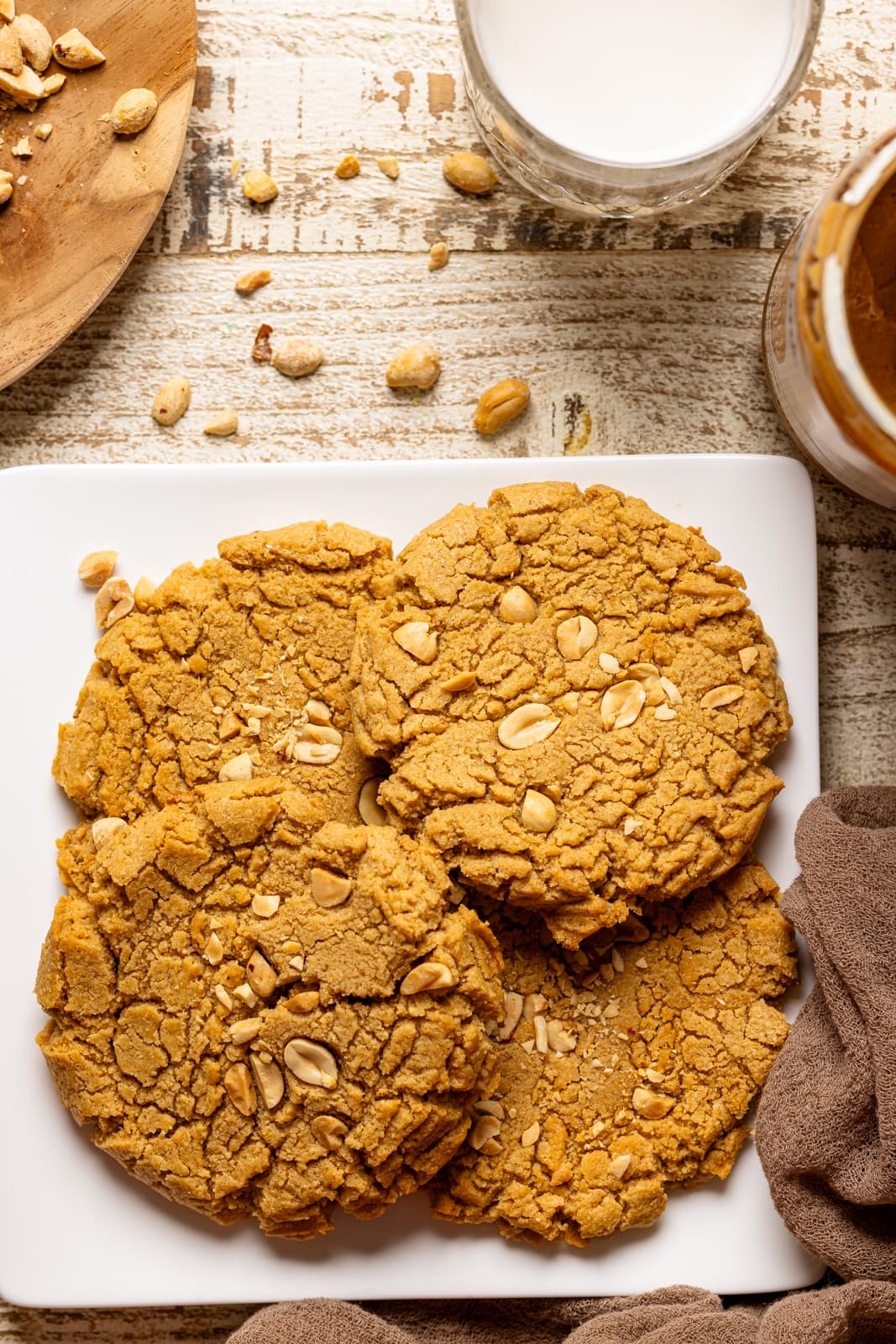 Up close shot of PB cookies on a white plate with chopped peanuts.