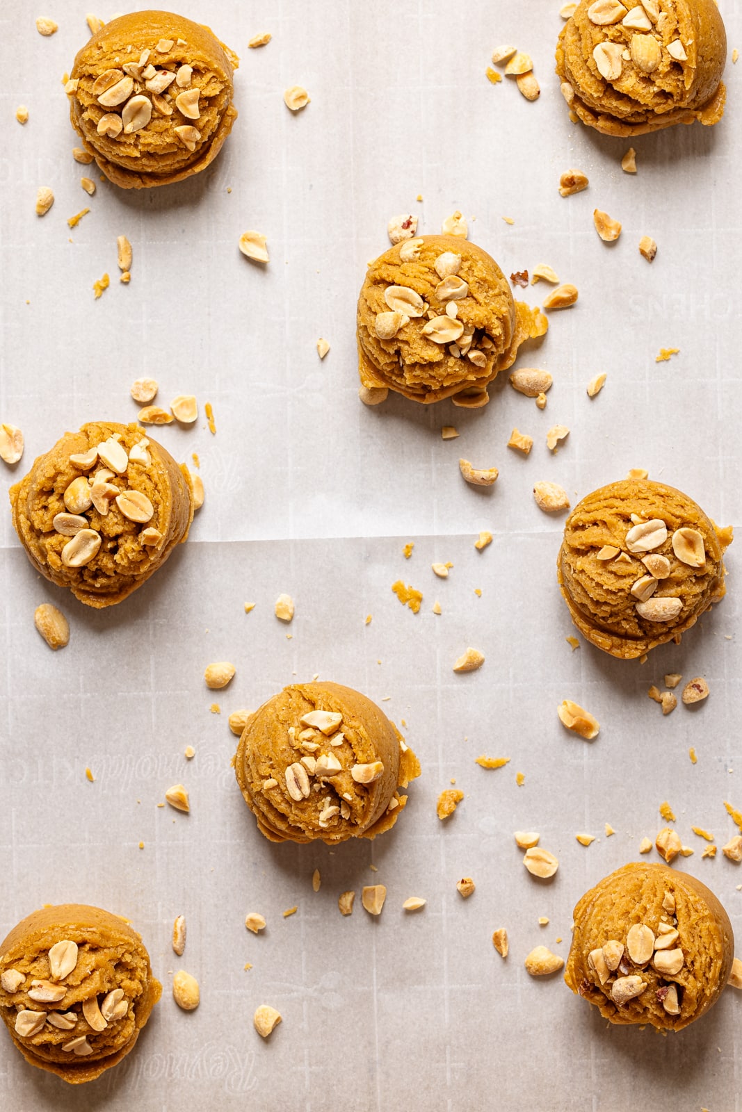 Cookies scooped and lined on a parchment paper.