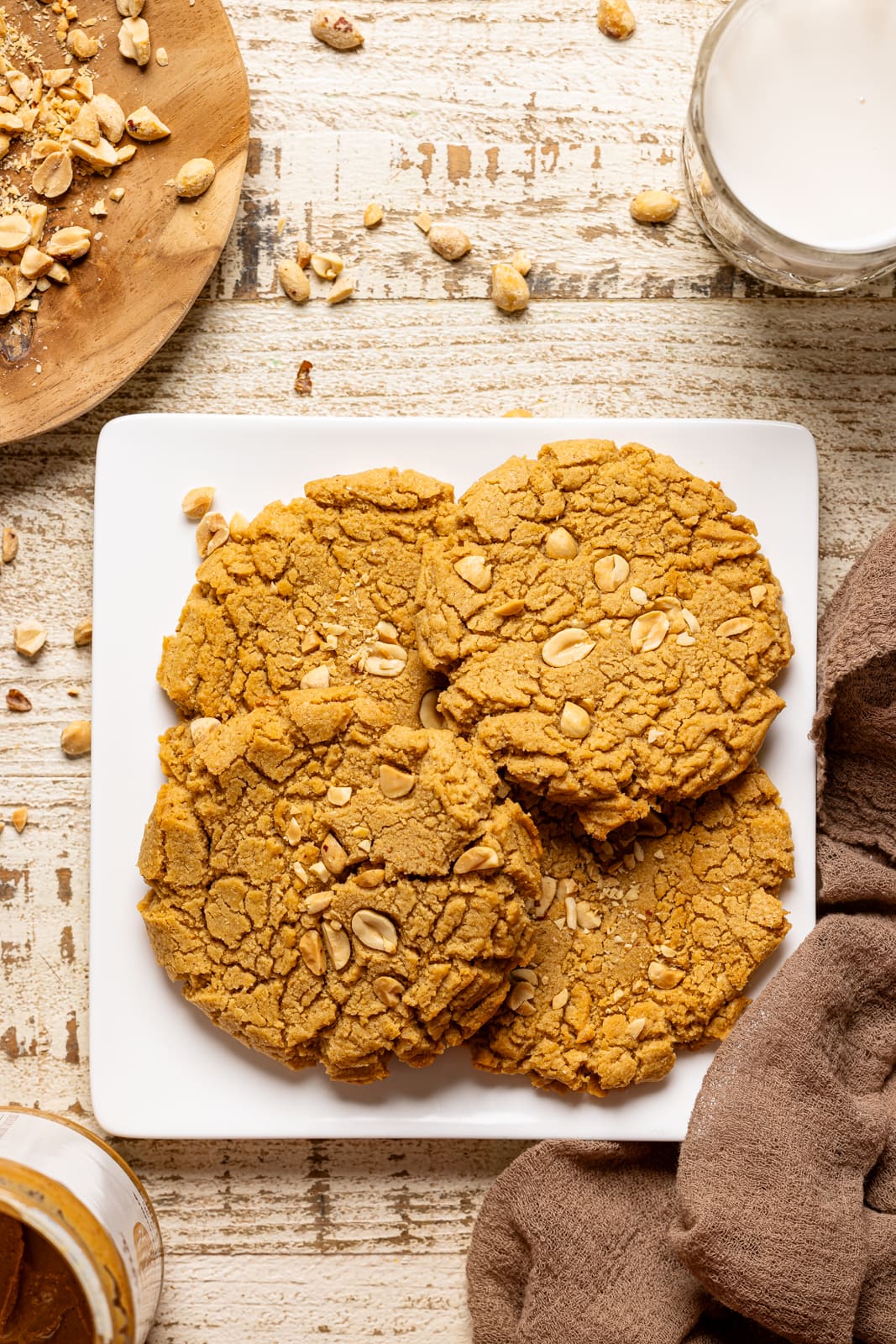 Cookies on a white plate with a side of milk.