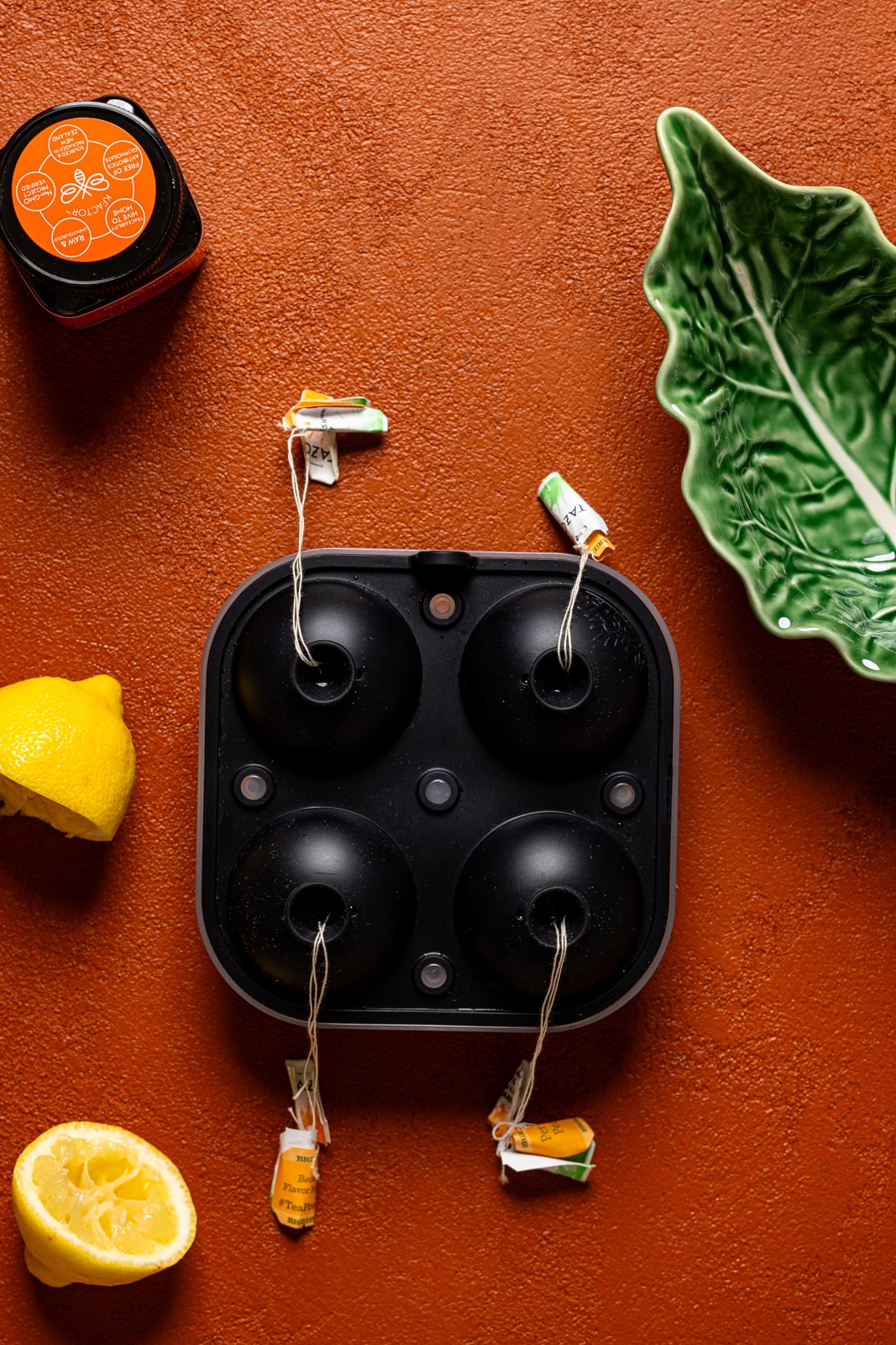 Ice cube trays with tea bags and lemon.