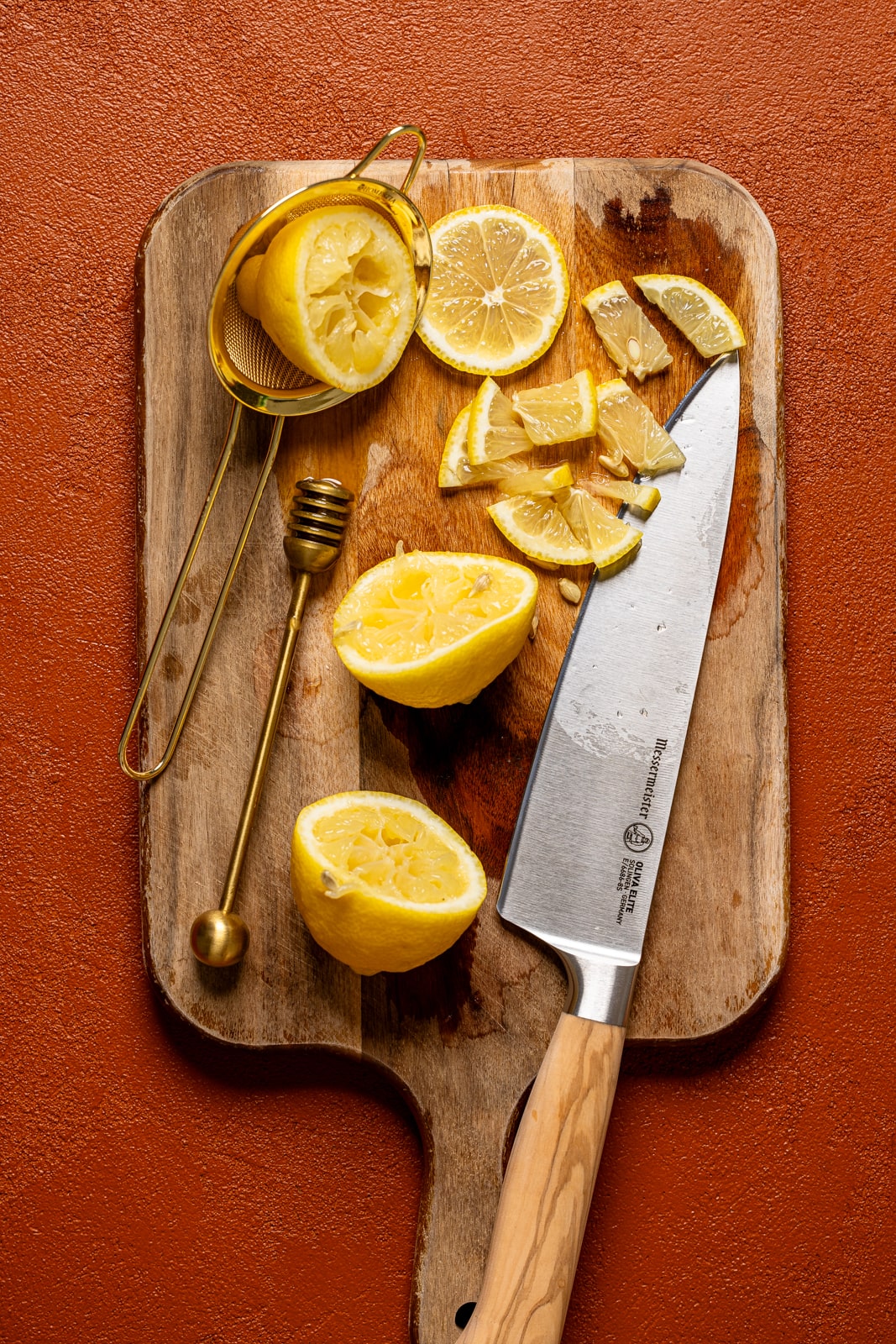 Sliced lemons on a cutting board with a knife.