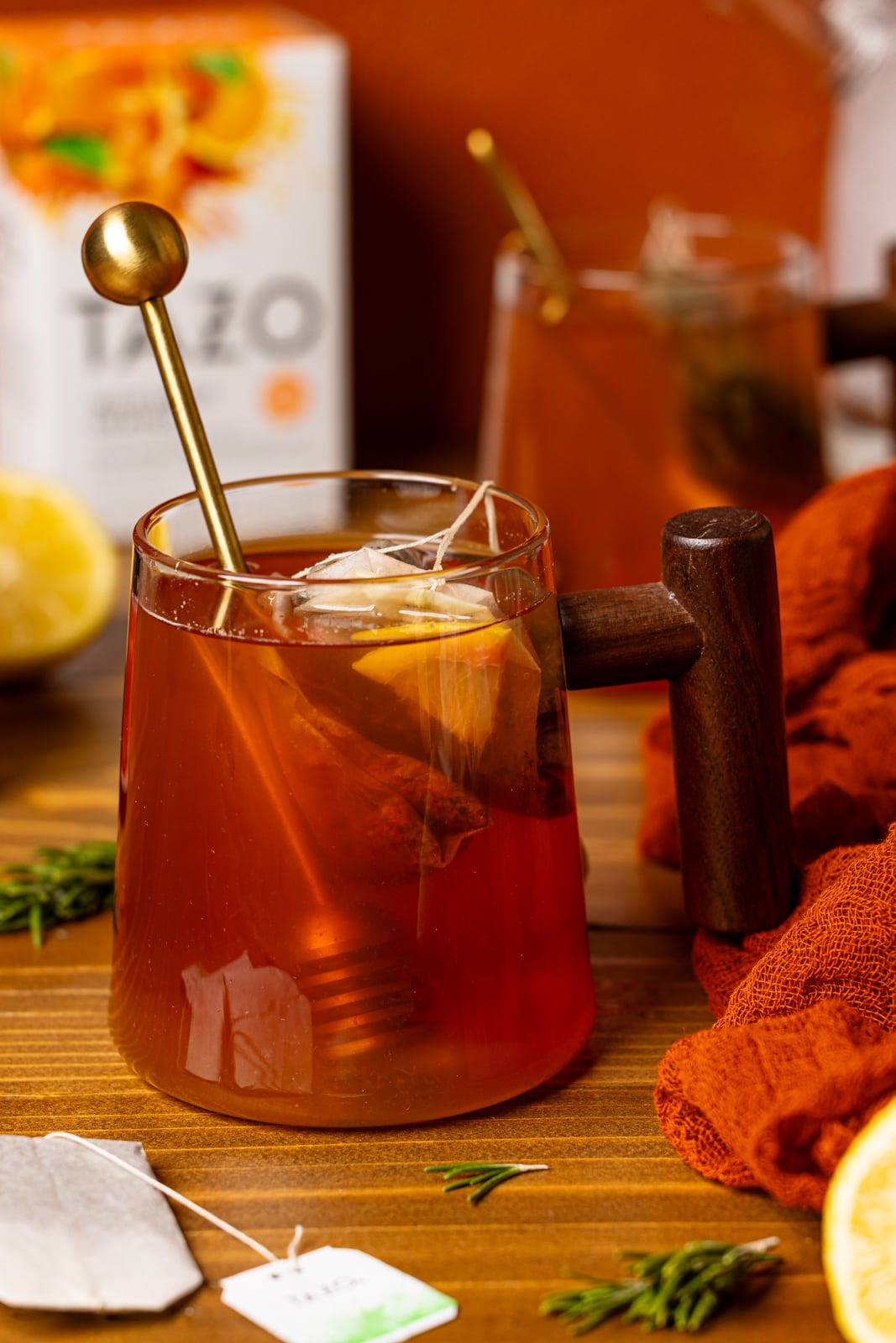 Tea with a box of tea bags and honey stick.