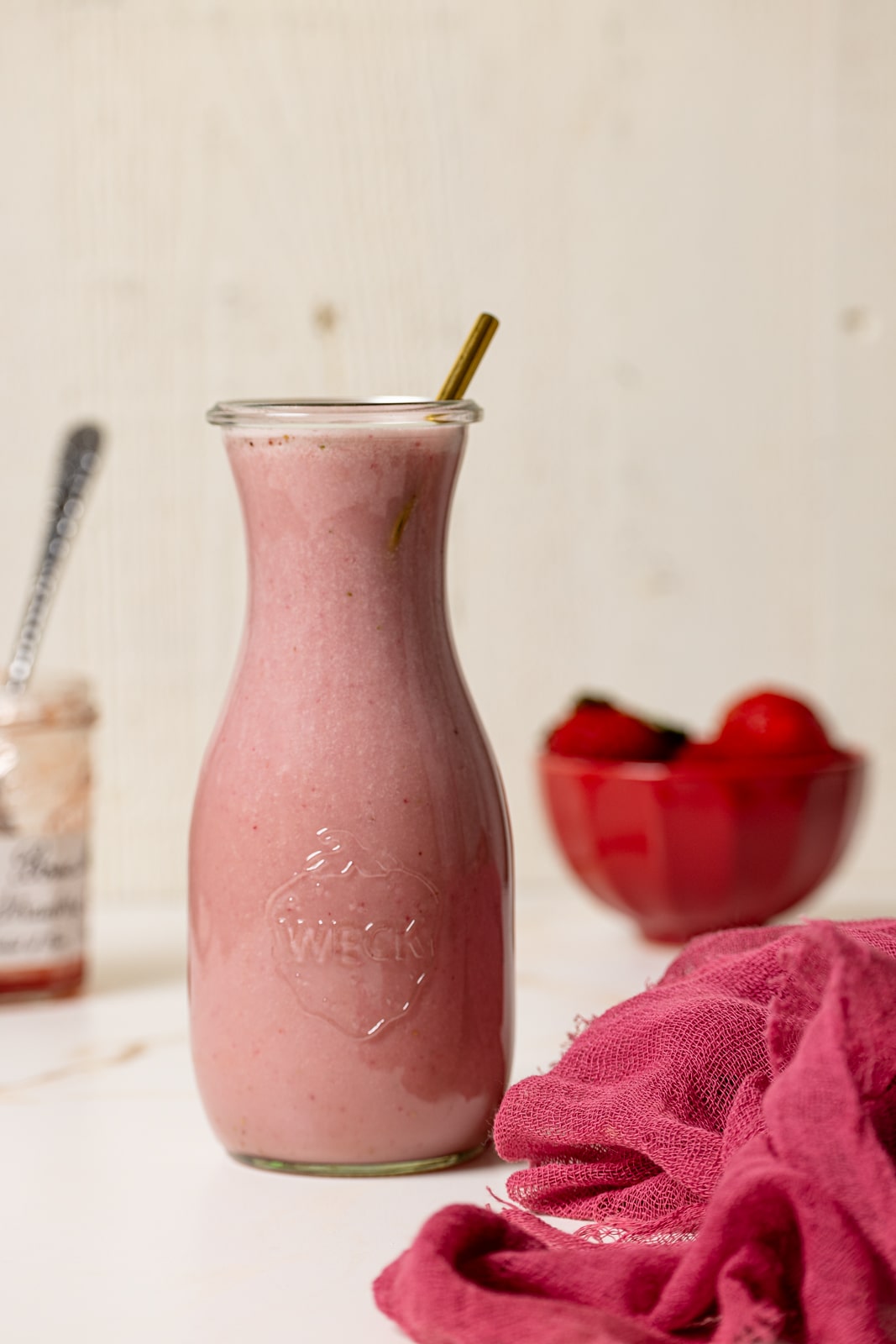 Strawberry milk in a jar with a straw.