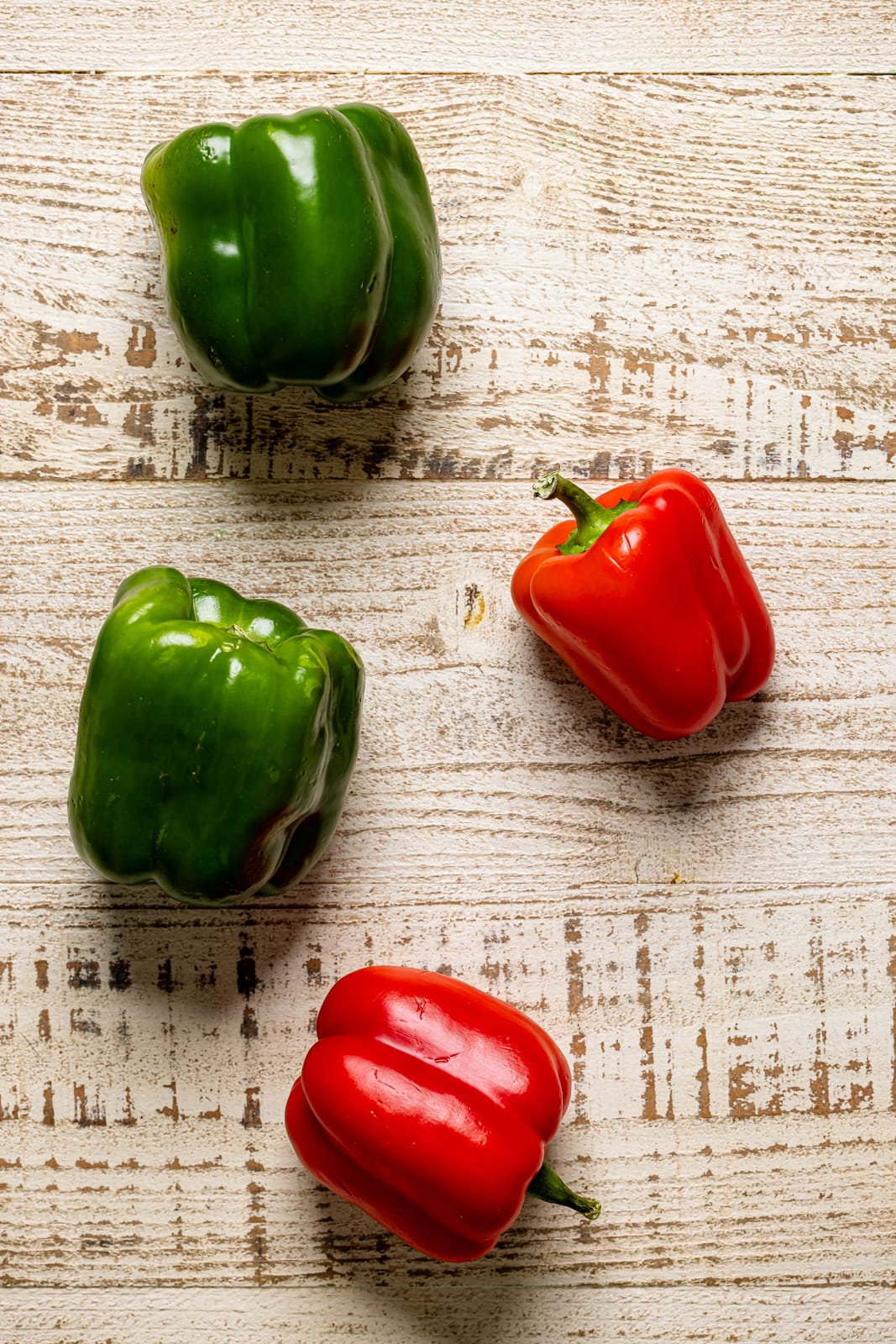 Bell peppers on a white wood table.