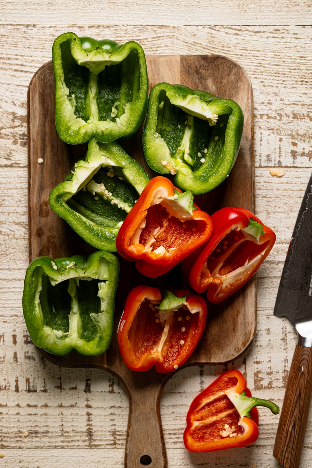Cut bell peppers on a cutting board with a knife.