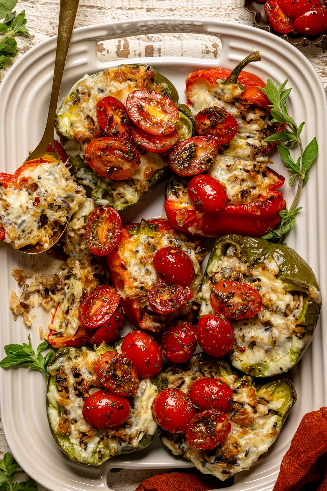 Up close shot of stuffed peppers on a serving tray with a spoon.