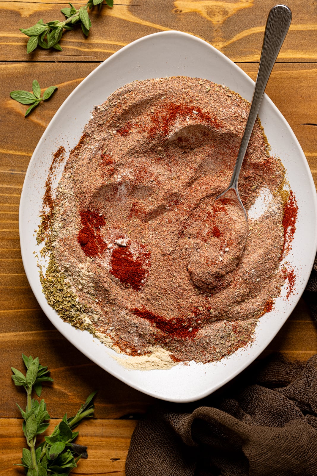 Seasoning stirred together on a white plate with a spoon.