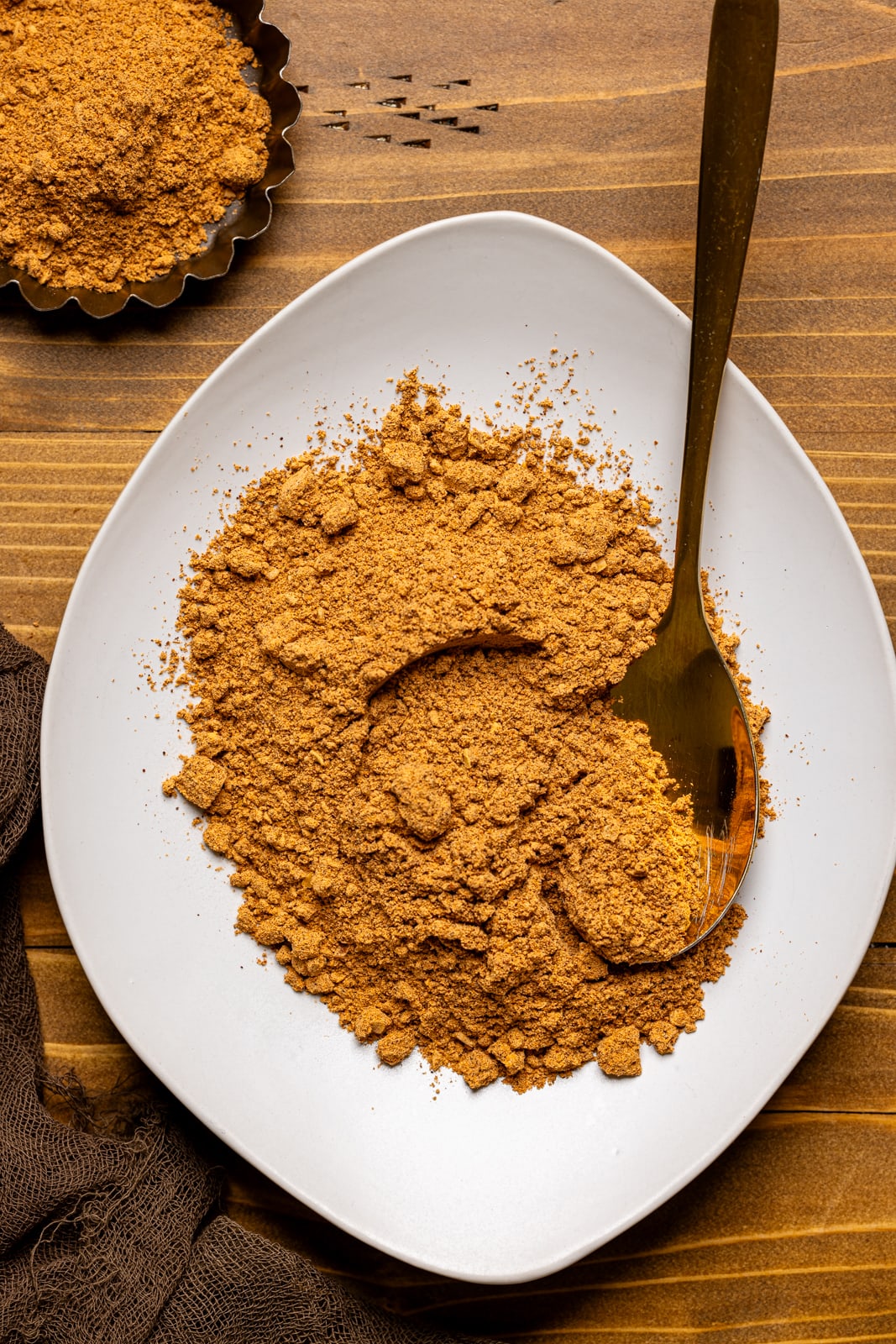 Seasoning on a white plate on a brown wood table.