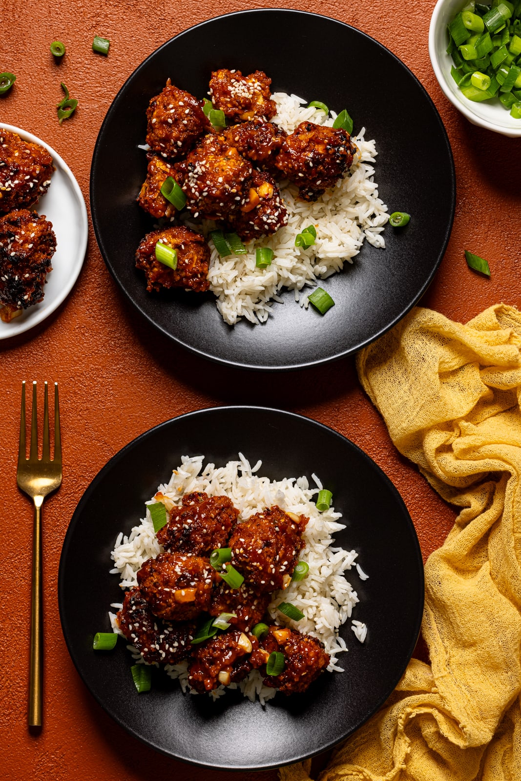 Two plates of General Tso Chicken with a fork.