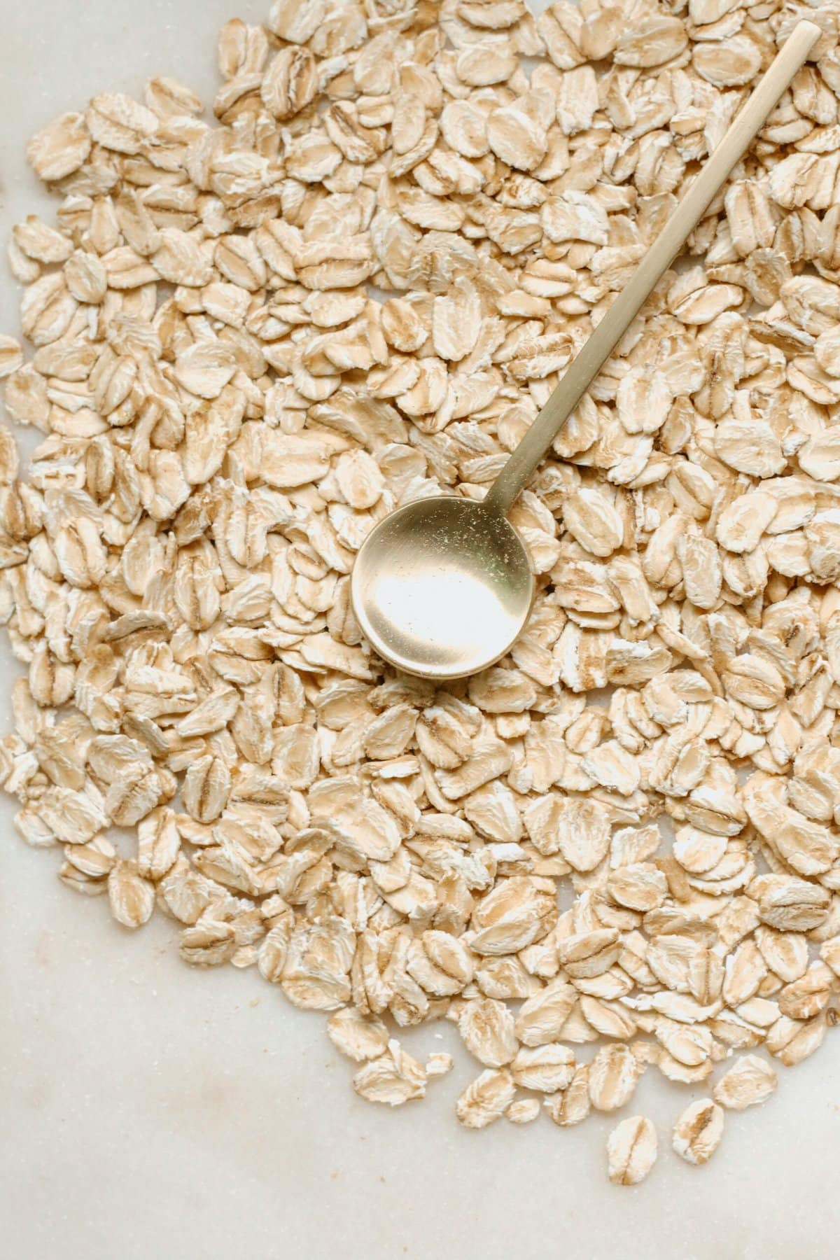 Oats on a table with a gold spoon.